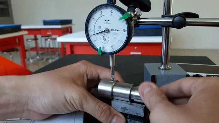 Kỹ thuật viên đang kiểm tra độ chính xác của đầu máy phay bằng đồng hồ so.